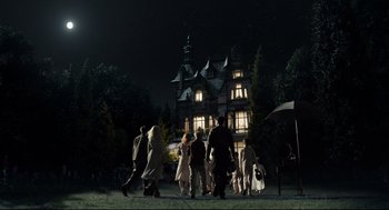 Movie still from “Miss Peregrine's Home for Peculiar Children” (2016), directed by Tim Burton – A group of people walking in front of a building; Wide shot, Low angle
