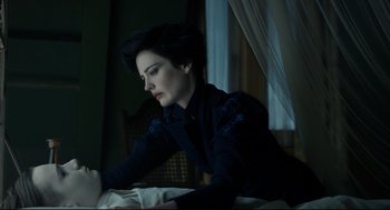 Movie still from “Miss Peregrine's Home for Peculiar Children” (2016), directed by Tim Burton – A woman sitting on top of a bed looking at a laptop; Close Up shot, High angle