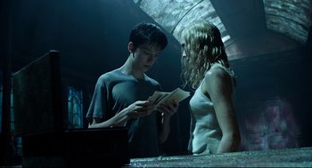 Movie still from “Miss Peregrine's Home for Peculiar Children” (2016), directed by Tim Burton – A man and a woman are looking at a book; Medium shot, Low angle