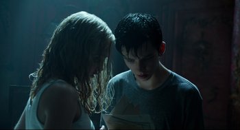 Movie still from “Miss Peregrine's Home for Peculiar Children” (2016), directed by Tim Burton – A young man and a young woman looking at a piece of paper; Medium shot, Low angle