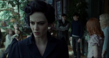 Movie still from “Miss Peregrine's Home for Peculiar Children” (2016), directed by Tim Burton – A woman in a black jacket looking at the camera with two other people in the background; Close Up shot, Over the shoulder angle