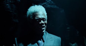 Movie still from “Miss Peregrine's Home for Peculiar Children” (2016), directed by Tim Burton – A man in a suit and tie with a white afro; Close Up shot, Over the shoulder angle