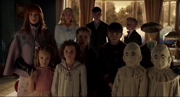 Movie still from “Miss Peregrine's Home for Peculiar Children” (2016), directed by Tim Burton – A group of people standing next to each other in front of a window; Medium shot, High angle