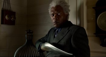 Movie still from “Miss Peregrine's Home for Peculiar Children” (2016), directed by Tim Burton – A man in a suit and tie holding a knife; Close Up shot, Over the shoulder angle