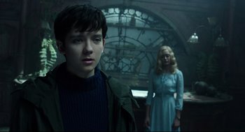 Movie still from “Miss Peregrine's Home for Peculiar Children” (2016), directed by Tim Burton – A boy and a woman in a room with a stained glass window behind them; Medium shot, Over the shoulder angle