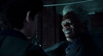 Movie still from “Miss Peregrine's Home for Peculiar Children” (2016), directed by Tim Burton – Two men in suits talking to each other in a dark room; Close Up shot, Over the shoulder angle