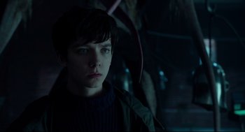 Movie still from “Miss Peregrine's Home for Peculiar Children” (2016), directed by Tim Burton – A young man in a dark room looking at the camera; Close Up shot, Over the shoulder angle