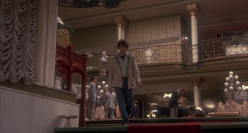 Movie still from “Missing” (1982), directed by Costa-Gavras – A man walking down the stairs of a building; Wide shot, High angle