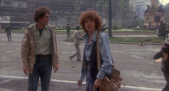 Movie still from “Missing” (1982), directed by Costa-Gavras – A woman walking down the street with a purse; Wide shot, Low angle