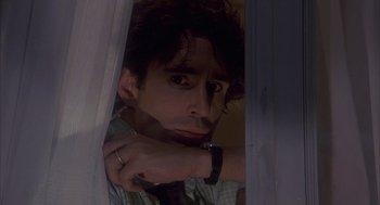 Movie still from “Missing” (1982), directed by Costa-Gavras – A man with a watch looking out of a window; Close Up shot, Low angle