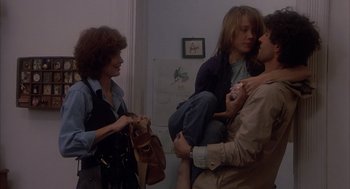 Movie still from “Missing” (1982), directed by Costa-Gavras – A group of people that are in a room together; Medium shot, Over the shoulder angle