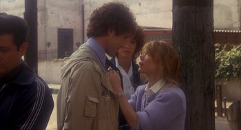 Movie still from “Missing” (1982), directed by Costa-Gavras – A man and a woman standing next to each other on the street; Medium shot, Over the shoulder angle