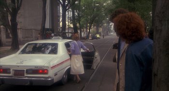Movie still from “Missing” (1982), directed by Costa-Gavras – A woman is getting into a car on the side of the road; Wide shot, Over the shoulder angle
