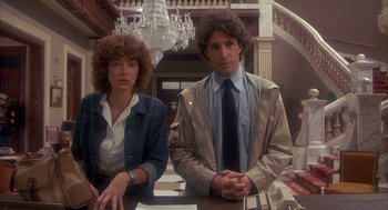 Movie still from “Missing” (1982), directed by Costa-Gavras – A man and a woman sitting at a table in front of chandeliers; Medium shot, Low angle