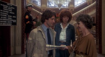 Movie still from “Missing” (1982), directed by Costa-Gavras – A man and a woman are holding a newspaper; Medium shot, Over the shoulder angle