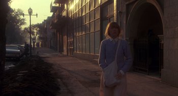 Movie still from “Missing” (1982), directed by Costa-Gavras – A woman standing on the side of a street; Wide shot, Low angle