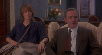 Movie still from “Missing” (1982), directed by Costa-Gavras – A man and a woman sitting in a living room next to each other; Medium shot, High angle