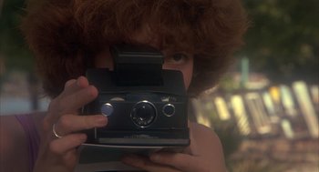 Movie still from “Missing” (1982), directed by Costa-Gavras – A person taking a picture with a camera; Extreme Close Up shot, Low angle