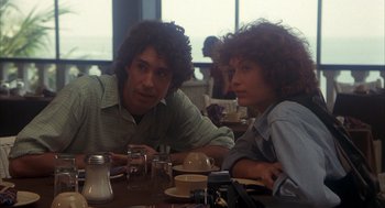 Movie still from “Missing” (1982), directed by Costa-Gavras – A man and a woman sitting at a table in a restaurant; Medium shot, Over the shoulder angle