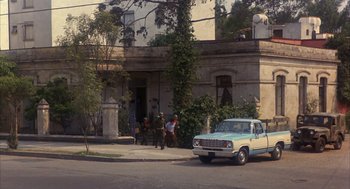 Movie still from “Missing” (1982), directed by Costa-Gavras – An old car parked on the side of the street; Extreme Wide shot, High angle