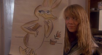 Movie still from “Missing” (1982), directed by Costa-Gavras – A woman standing next to a drawing of a duck; Close Up shot, Over the shoulder angle