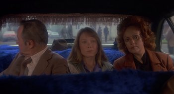 Movie still from “Missing” (1982), directed by Costa-Gavras – A group of people sitting in a bus; Medium shot, High angle
