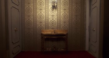 Movie still from “Missing” (1982), directed by Costa-Gavras – A table with a sink in front of a wall with wallpaper; Extreme Wide shot, Overhead angle