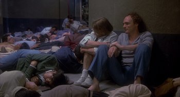 Movie still from “Missing” (1982), directed by Costa-Gavras – A group of people laying on the ground; Wide shot, High angle