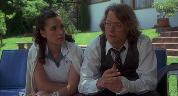 Movie still from “Missing” (1982), directed by Costa-Gavras – A man and a woman sitting next to each other; Medium shot, Low angle