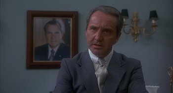 Movie still from “Missing” (1982), directed by Costa-Gavras – A person wearing a suit and tie; Close Up shot, Low angle