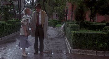 Movie still from “Missing” (1982), directed by Costa-Gavras – An older man and woman walking down a sidewalk; Wide shot, Low angle