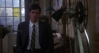 Movie still from “Missing” (1982), directed by Costa-Gavras – A man wearing a suit and tie standing in front of a mirror; Medium shot, High angle