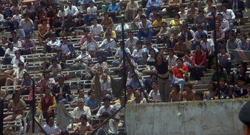 Movie still from “Missing” (1982), directed by Costa-Gavras – A crowd of people sitting in a stadium; Extreme Wide shot, High angle