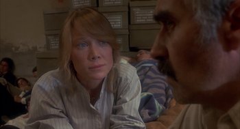 Movie still from “Missing” (1982), directed by Costa-Gavras – A man and a woman sitting on the floor; Close Up shot, Over the shoulder angle