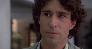 Movie still from “Missing” (1982), directed by Costa-Gavras – A person with curly brown hair; Close Up shot, Low angle