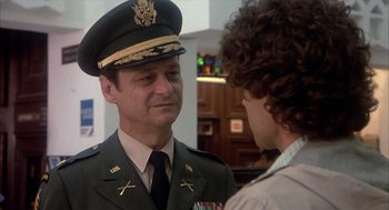 Movie still from “Missing” (1982), directed by Costa-Gavras – A man in a uniform talking to another man in a uniform; Close Up shot, Over the shoulder angle