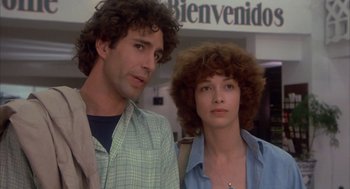 Movie still from “Missing” (1982), directed by Costa-Gavras – A man and a woman standing next to each other; Close Up shot, Low angle