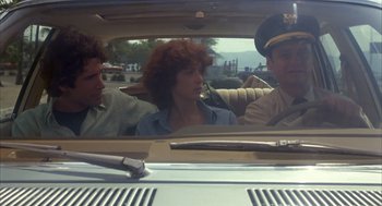 Movie still from “Missing” (1982), directed by Costa-Gavras – A group of people sitting in the back of a car; Medium shot, Low angle