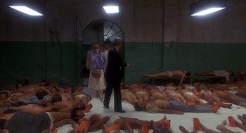 Movie still from “Missing” (1982), directed by Costa-Gavras – A group of people laying on the ground; Wide shot, High angle