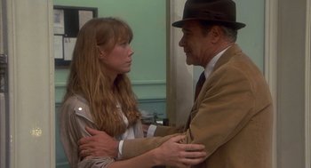 Movie still from “Missing” (1982), directed by Costa-Gavras – An older man and a young woman are holding hands; Medium shot, Over the shoulder angle