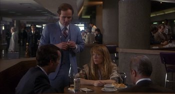 Movie still from “Missing” (1982), directed by Costa-Gavras – A group of people sitting at a table in a restaurant; Medium shot, Over the shoulder angle