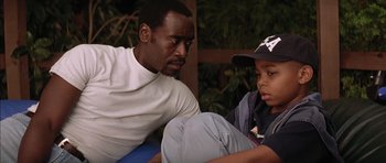 Movie still from “Mission to Mars” (2000), directed by Brian De Palma – A man and a boy sitting next to each other; Close Up shot, Over the shoulder angle