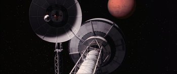 Movie still from “Mission to Mars” (2000), directed by Brian De Palma – An image of a space station in the dark; Extreme Wide shot, Overhead angle