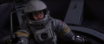 Movie still from “Mission to Mars” (2000), directed by Brian De Palma – A person in a spacesuit is standing in the dark; Medium shot, Overhead angle