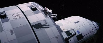 Movie still from “Mission to Mars” (2000), directed by Brian De Palma – An image of an astronaut on the side of a space ship; Wide shot, Overhead angle
