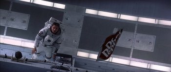 Movie still from “Mission to Mars” (2000), directed by Brian De Palma – A man standing in front of a bag of cereal; Wide shot, Overhead angle