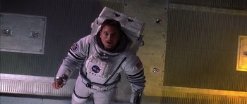 Movie still from “Mission to Mars” (2000), directed by Brian De Palma – A man in a spacesuit standing next to a wall; Medium shot, Overhead angle