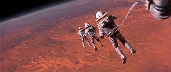 Movie still from “Mission to Mars” (2000), directed by Brian De Palma – A group of people in spacesuits flying over an expanse of earth; Wide shot, Overhead angle