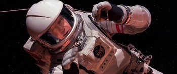 Movie still from “Mission to Mars” (2000), directed by Brian De Palma – A man in a spacesuit is holding a compass; Medium shot, Overhead angle