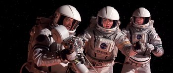 Movie still from “Mission to Mars” (2000), directed by Brian De Palma – Two people in spacesuits are posing for a picture; Medium shot, Overhead angle